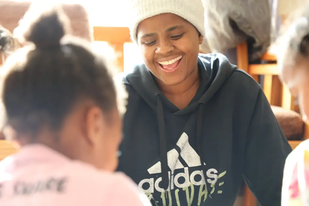 Childcare worker laughs with children